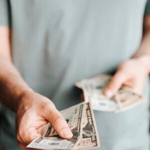 Crop man paying with American dollars